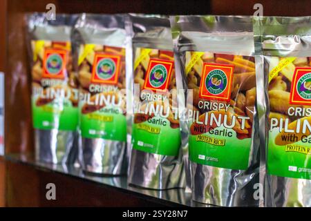 Des paquets de noix de pili caramélisées vendues dans un centre touristique de Bicol, aux Philippines, une délicatesse sucrée et croquante populaire parmi les visiteurs et les habitants Banque D'Images