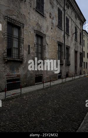 Façade usée d'un palais dans une rue pavée d'une ville italienne Banque D'Images