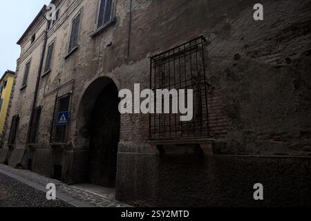 Façade usée d'un palais dans une rue pavée d'une ville italienne Banque D'Images