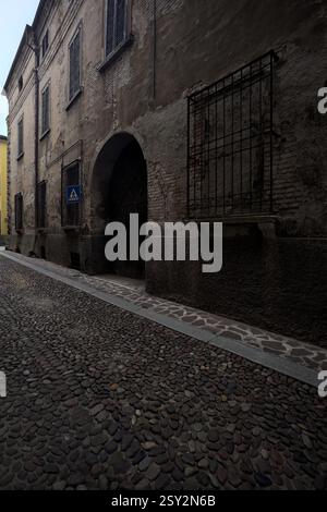 Façade usée d'un palais dans une rue pavée d'une ville italienne Banque D'Images