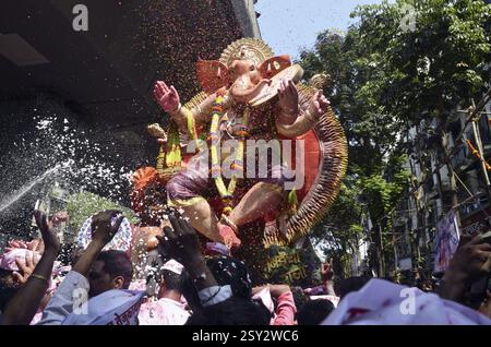 Les gens versent des pétales de fleurs sur Ganpati Mumbai Maharashtra Inde Banque D'Images