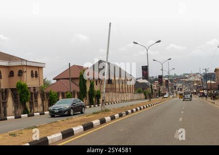 Lower Presidential Road Enugu avec des véhicules, des lampadaires et des bâtiments, paysage urbain du Nigeria montrant les transports, les infrastructures et le développement Banque D'Images