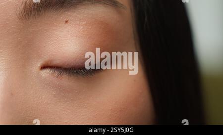 Extrême close up femme yeux sombres détails asiatique femme fille coréenne chinois ethnique saine japonaise dame vue oeil humain fermant iris oeil oculaire cligner Banque D'Images