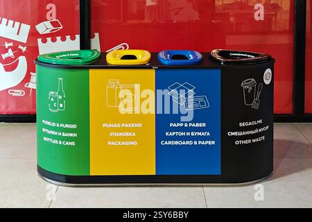 Ensemble de quatre bacs de recyclage à code couleur étiquetés pour les bouteilles, les emballages, le papier et les déchets mélangés, favorisant la sensibilisation à l'environnement et l'élimination appropriée des déchets Banque D'Images