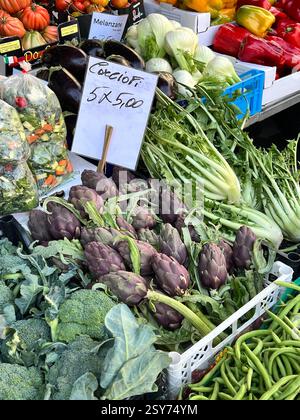 Une exposition vibrante d'artichauts frais, de brocolis, de poivrons et plus encore dans un marché de fermiers. Banque D'Images