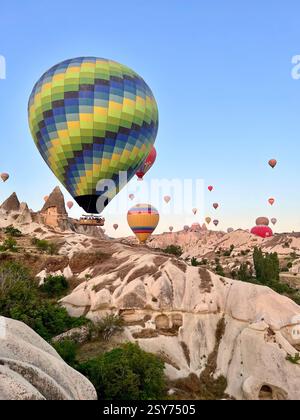 Montgolfières colorées flottant au-dessus des formations rocheuses uniques de Cappadoce, Turquie Banque D'Images