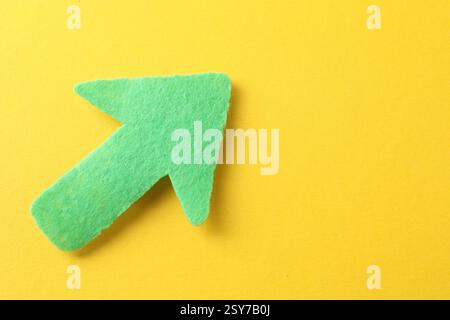 Une flèche verte sur fond jaune, vue de dessus. Espace pour le texte Banque D'Images