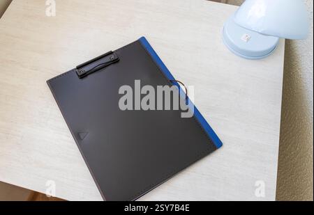 Photo de la chemise en plastique sur le bureau avec support trombone sur le dessus Banque D'Images