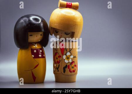 Poupées Kokeshi, isolées sur un fond gris Banque D'Images