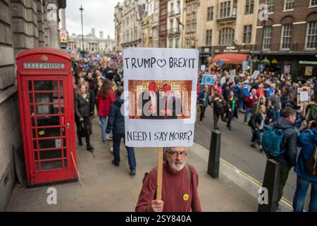 Un homme brandit une bannière disant que Trump aime le Brexit au-dessus d’une photo de Donald Trump et du politicien britannique Nigel Farage lors de la marche anti-Brexit et du rassemblement « Put it to the People » dans le centre de Londres en mars 2019. Banque D'Images