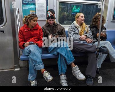 Distrait les voyageurs de la génération Z dans le métro de New York le vendredi 14 février 2025. (© Richard B. Levine) Banque D'Images