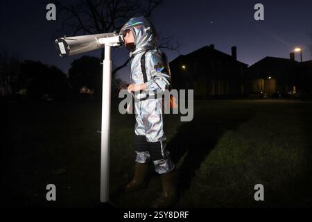 Chichester, West Sussex, Royaume-Uni. Oscar, 5 ans, photographié en regardant la parade planétaire de 2025, un moment sept planètes - mars, Jupiter, Uranus, Vénus, Neptune, mercure et Saturne seront tous brièvement visibles dans le ciel du soir - la dernière fois que sept planètes seront visibles dans le ciel nocturne jusqu'en 2040. Oscar regarde Vénus. Banque D'Images