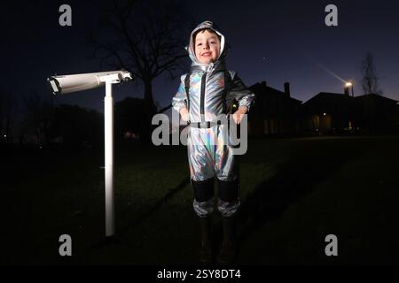 Chichester, West Sussex, Royaume-Uni. Oscar, 5 ans, photographié en regardant la parade planétaire de 2025, un moment sept planètes - mars, Jupiter, Uranus, Vénus, Neptune, mercure et Saturne seront tous brièvement visibles dans le ciel du soir - la dernière fois que sept planètes seront visibles dans le ciel nocturne jusqu'en 2040. Oscar regarde Vénus. Banque D'Images