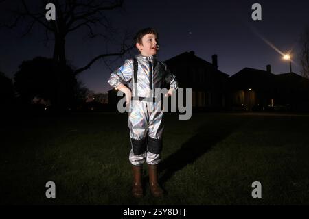Chichester, West Sussex, Royaume-Uni. Oscar, 5 ans, photographié en regardant la parade planétaire de 2025, un moment sept planètes - mars, Jupiter, Uranus, Vénus, Neptune, mercure et Saturne seront tous brièvement visibles dans le ciel du soir - la dernière fois que sept planètes seront visibles dans le ciel nocturne jusqu'en 2040. Oscar regarde Vénus. Banque D'Images
