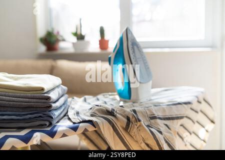 Fer à repasser électrique et la pile de vêtements à repasser Banque D'Images