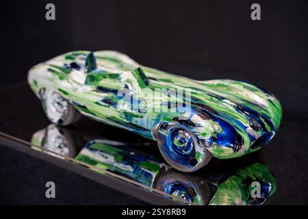 Sculpture en verre coloré d'une voiture de course mettant en valeur le flair artistique dans une exposition moderne Banque D'Images