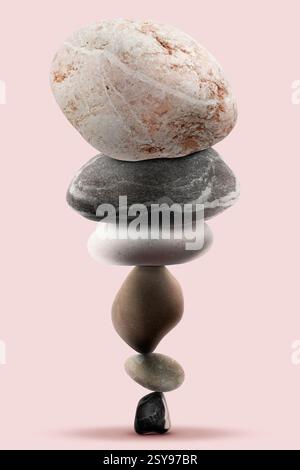 Équilibre montré sous forme de pierres empilées sur fond rose Banque D'Images