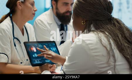 Radiologues équipe diversifiée examinant les radiographies pour discuter des soins prodigués aux patients dans un établissement. Équipe de spécialistes de la santé qualifiés travaillant ensemble pour fournir un diagnostic et des plans de traitement précis. Caméra A. Banque D'Images