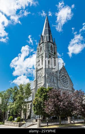 Grande église avec un clocher et une croix sur le dessus. Le bâtiment est entouré d'arbres Banque D'Images