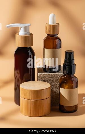 Une collection de bouteilles cosmétiques en verre brun avec des bouchons en bois affichés sur un fond beige. Le design minimaliste met l'accent sur la beauté naturelle et le mod Banque D'Images