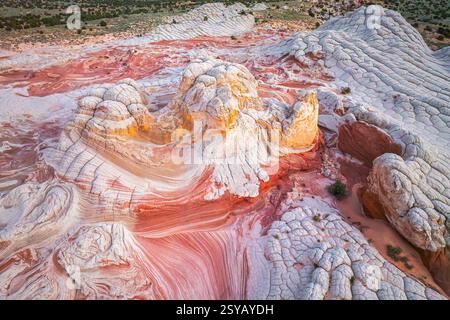 Vue aérienne des formations rocheuses tourbillonnantes dans des tons rouges et blancs éclatants dans White Pocket, mettant en valeur les motifs complexes et les textures créés par Natural Banque D'Images