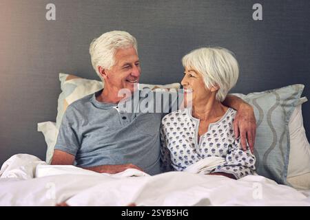 Couple aîné, câlin et se réveiller dans le lit avec le sourire, le soin et la gratitude pour commencer la journée avec amour à la retraite. Homme âgé, femme et embrasser avec loyauté Banque D'Images