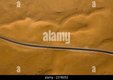 Vue aérienne d'une route droite traversant des dunes de sable dans le désert du Sahara, Algérie, Afrique du Nord. Banque D'Images
