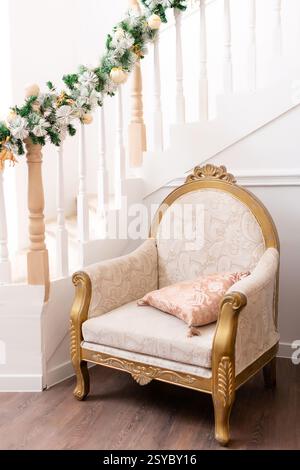 chaise en bois doré dans le couloir près des escaliers. lieu de repos dans une maison de deux étages Banque D'Images