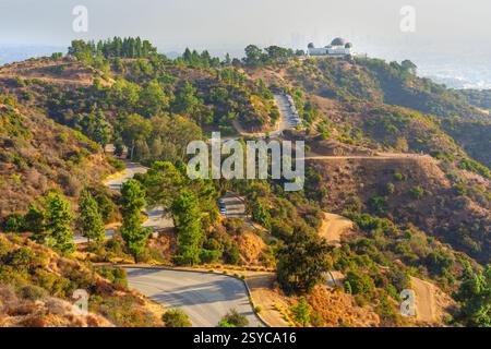 Vue aérienne de l'observatoire Griffith avec des routes sinueuses et des collines luxuriantes, mettant en vedette une destination touristique populaire à Los Angeles. Banque D'Images