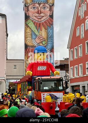 27.02.2025, Faschingsumzug in Mindelheim im Unterallgäu, Am Gumpigen Donnerstag. Ein bunter Gaudiwurm zieht sich durch die historische Altstadt, gesäumt von tausenden feierwütigen Zuschauern. Durahansl Mindelheim, Faschingsbrauch : der wohl größte Faschingsnarr der Welt : 21 Meter misst der Durahansl von der gelb-blauen Narrenkappe bis zu den Schuhen mit rotem Bommel. Schon seit 1909 schmücken Einwohner des Unterallgäuer Städtchens Mindelheim Bayern das Obere Tor zur fünften Jahreszeit mit dem überdimensionalen Faschingskasper an der Turm-Fassade in der Altstadt. Die Mindelheimer Turmfiguren ble Banque D'Images