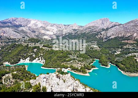 Lac de montagne turquoise entouré de forêts denses, collines en terrasses. Guadalest. Capturée par un drone, cette image met en valeur la beauté naturelle étonnante Banque D'Images