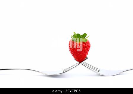 Fraise sur fourchette en métal isolé sur fond blanc. Nature morte. Banque D'Images