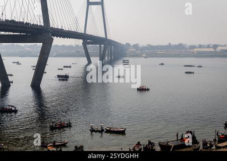 Pèlerins sur le bateau traversant le pont de route artistique sur le fleuve sacré du gange pour le sangam à mahakumbh image est prise au New Yamuna Bridge mahakumbh mela Banque D'Images