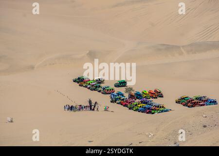 Un groupe de voyageurs aventureux chevauchant des buggies à travers les dunes de sable doré près de l'oasis de Huacachina à ICA Pérou Banque D'Images