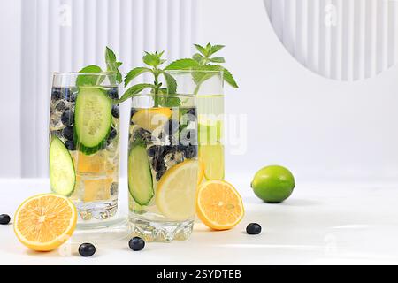 Détox eau avec des saveurs de citron, concombre, myrtille et menthe sur un fond clair. Un cocktail rafraîchissant de limonade maison d'été. Jus de fruits et dans Banque D'Images