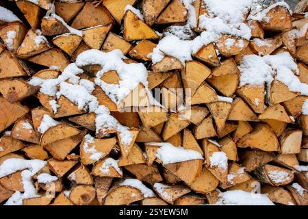 un tas de bois extérieur recouvert de neige, bûches pour l'allumage, fond Banque D'Images