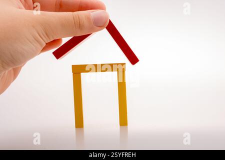 Hand holding pièces domino formant une forme de maison Banque D'Images