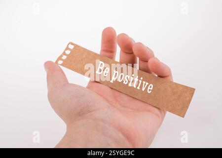 Papier déchiré par la main tenant à être pensée positive concept label Banque D'Images