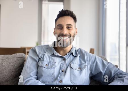 Le gars hispanique habillé regarde la caméra avec une expression joyeuse Banque D'Images