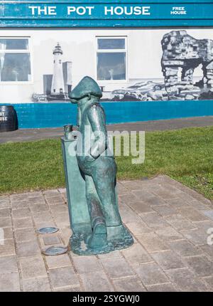 Statue d'Andy Capp, un célèbre personnage de dessin animé créé par Reg Smythe et situé à Hartlepool, Angleterre, Royaume-Uni. Pub pot House en arrière-plan Banque D'Images