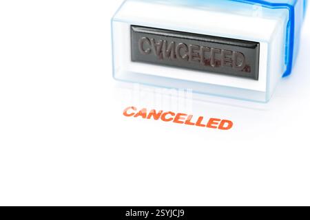 Timbre rouge avec le mot Annuler sur papier blanc avec le timbre placé dessus. Banque D'Images