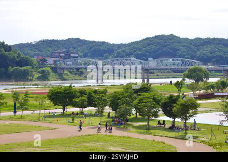 Ville de Gongju, Corée du Sud - 27 mai 2021 : un pont en treillis d'acier enjambe la rivière Geum, reliant le centre-ville de Gongju, tandis qu'un parc au bord de la rivière fournit Banque D'Images