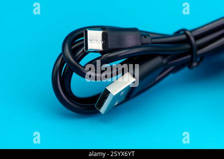 Warminster, Wiltshire, Royaume-Uni - novembre 30 2024 : gros plan d'un câble USB-A vers USB-C universel isolé sur un fond bleu Banque D'Images