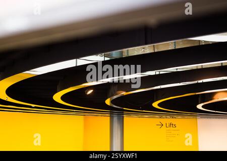 Plafond circulaire noir et jaune au salon London's Living Room, indiquant l'emplacement des ascenseurs. Banque D'Images