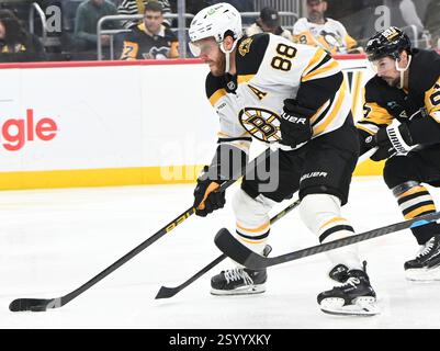 Pittsburgh, États-Unis. 01 mars 2025. Le défenseur des pingouins Erik Karlsson (65 ans) reçoit une pénalité de déclenchement alors que l'aile droite des Boston Bruins David Pastrnak (88 ans) prend le tir au but lors de la troisième période de la victoire des Boston Bruins 3-2 au PPG Paints Arena de Pittsburgh le samedi 1er mars 2025. Photo par Archie Carpenter/UPI. Crédit : UPI/Alamy Live News Banque D'Images