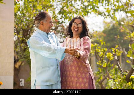 Portrait de couple heureux dansant ensemble dans le jardin Banque D'Images