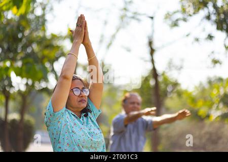 Couple mature faisant de l'exercice dans le parc public Banque D'Images