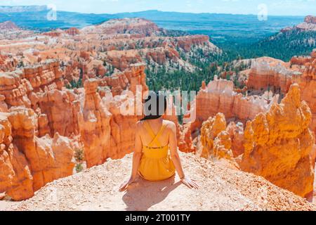 Femme randonneuse à Bryce Canyon se reposant profitant de la vue dans un magnifique paysage naturel avec des hoodoos, des pinacles et des flèches rocheuses formatio Banque D'Images