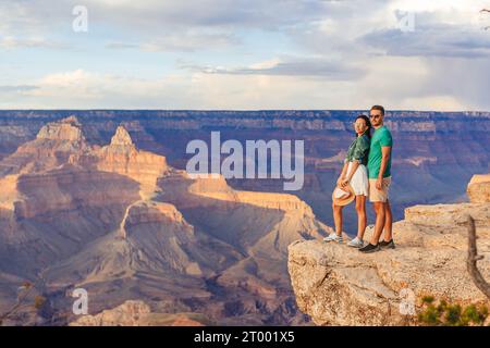 Couple heureux sur une falaise escarpée en profitant de la vue imprenable sur le célèbre Grand Canyon sur un magnifique coucher de soleil, Grand Canyon National P Banque D'Images