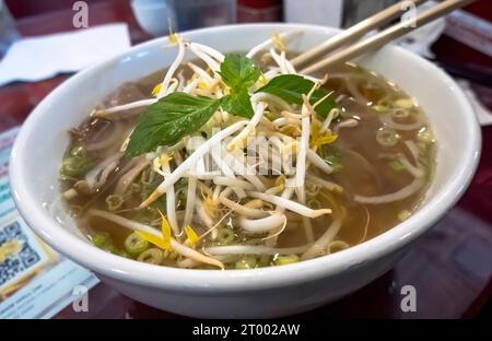 Pho un plat de soupe vietnamien composé de bouillon, de nouilles de riz, d'herbes et de viande. Un aliment populaire au Vietnam où il est servi en h. Banque D'Images